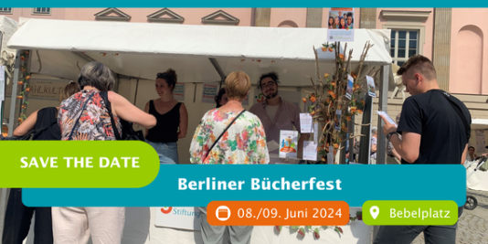 Personen stehen in und um einen Stand mit Infromationsmaterial zu Stiftung Bildung