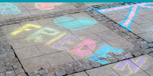 Das Wort Frieden mit bunter Kreide auf grauen Asphalt gemalt