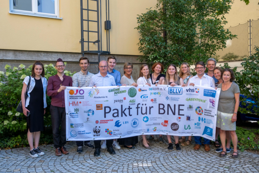 Unterzeichner*innen des Pakts mit Banner