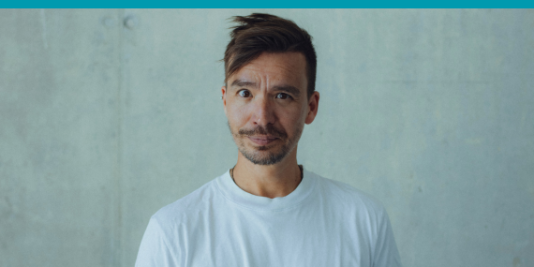 Ein Mann vor einer grauen Wand.