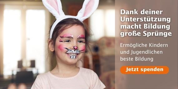 Ein lächelndes Mädchen trägt Hasenohren und ist wie ein Hase geschminkt.