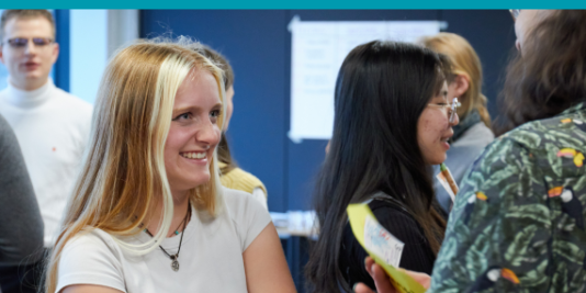 Jugendliche stehen in einem Raum und unterhalten sich